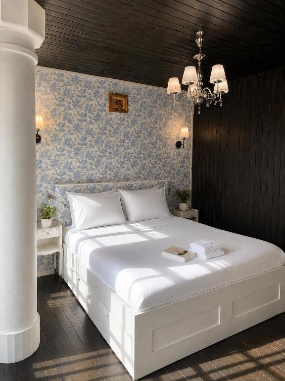 a bedroom with a white bed and a blue wall at Domaine de la Jasseix in Croze