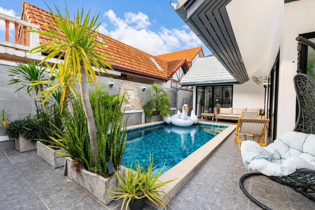 a pool in the backyard of a house with plants at Luxury Pool Villa Pattaya Center C8 - 4 Bedroom in Pattaya South