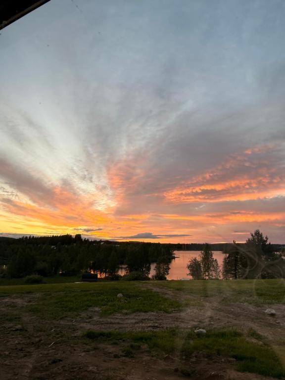 a sunset over a body of water in a field at Fishermans luck in Arvidsjaur