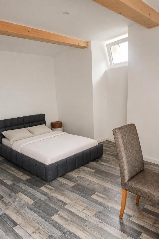 a bedroom with a bed and a chair at Au bord de La Boëme in Mouthiers-sur-Boëme