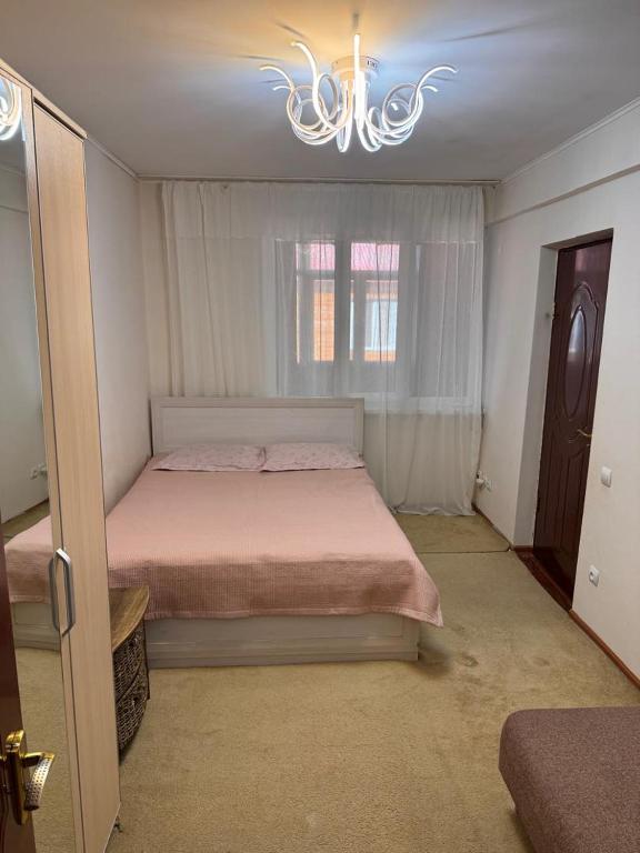 a bedroom with a bed and a chandelier at Issyk-Kul in Balykchy