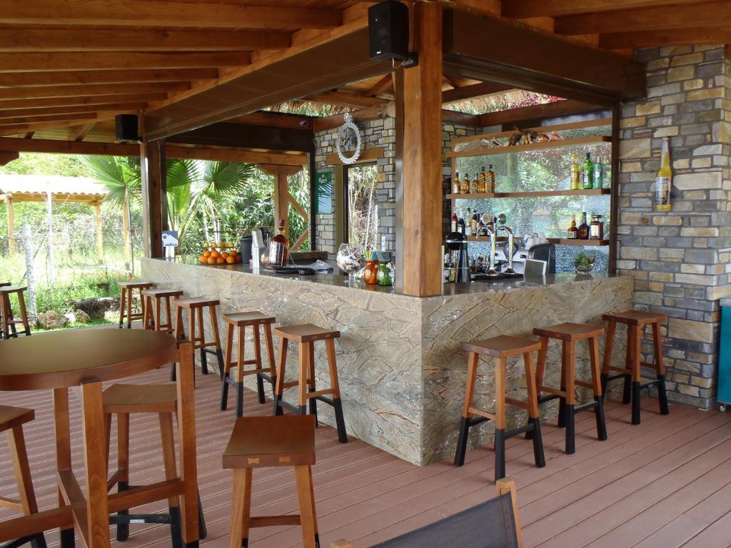 a bar on a deck with wooden stools at Vergos Hotel in Vourvourou