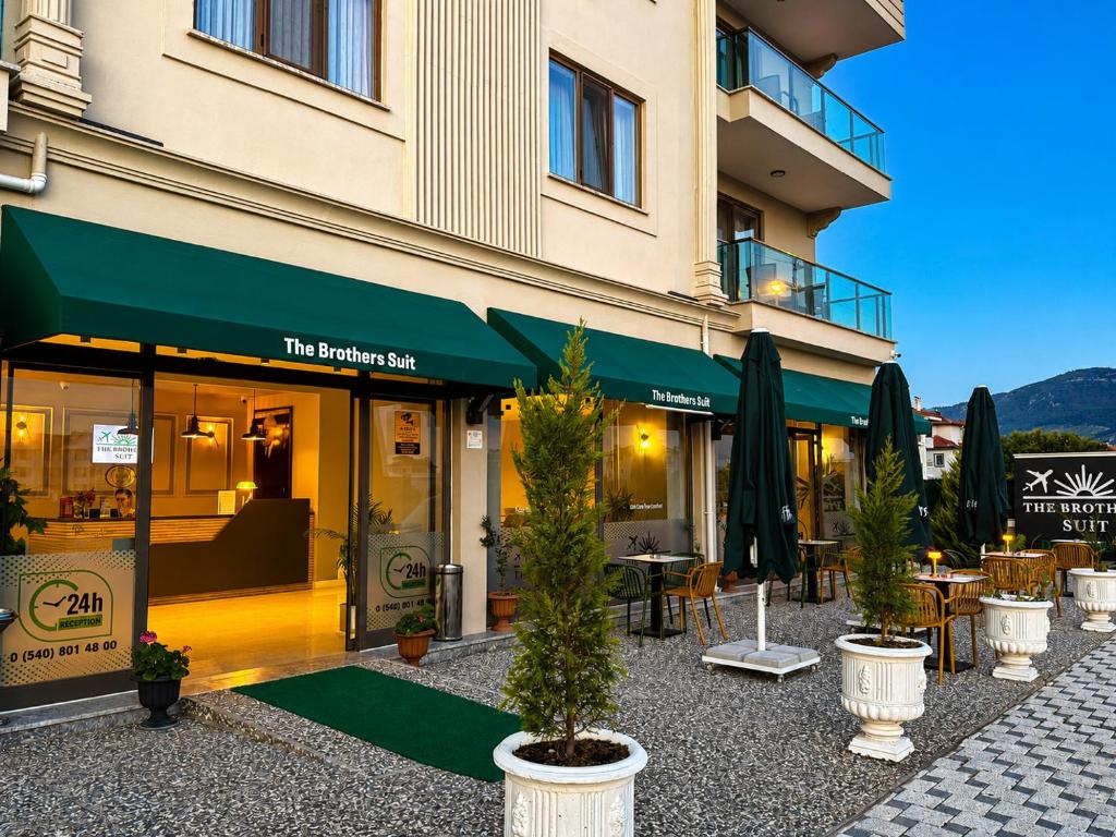 a hotel with tables and potted trees in front of a building at The Brothers Suite Dalaman in Dalaman