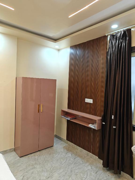 a bedroom with a wardrobe and a curtain at Diksha Heritage In in Prayagraj