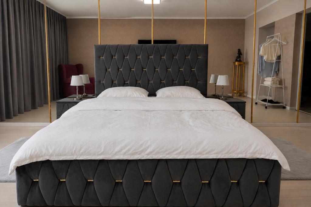 a large bed with a black headboard in a bedroom at Azur House in Cluj-Napoca