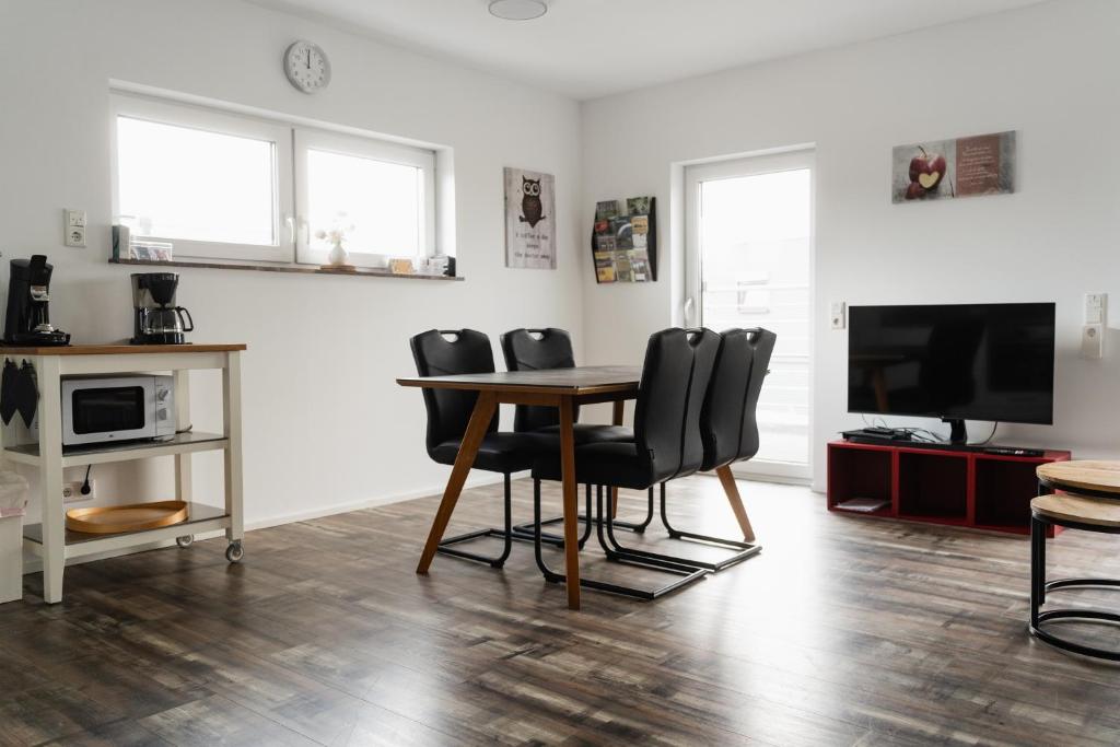 a living room with a table and chairs and a tv at Fewo 14 DG in Goch