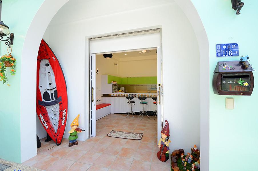 a living room with a room with a surfboard and a tv at 跳跳包棟民宿 in Xiaoliuqiu