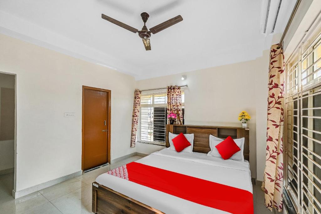 a bedroom with a large bed with red pillows at Hotel O Dream Marion in Bhubaneshwar