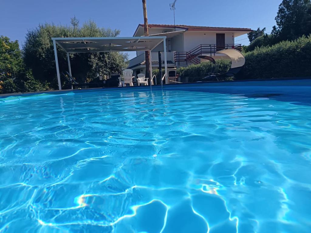 a swimming pool with blue water in front of a house at Villa Hippodrom-INDEPENDENT VILLA WITH POOL in Syracuse