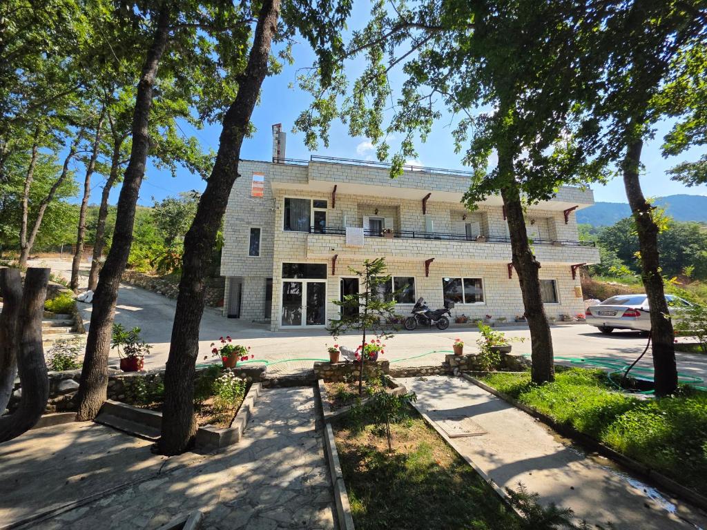 a building with trees in front of it at Hotel Restaurant Ujimira in Radomirë