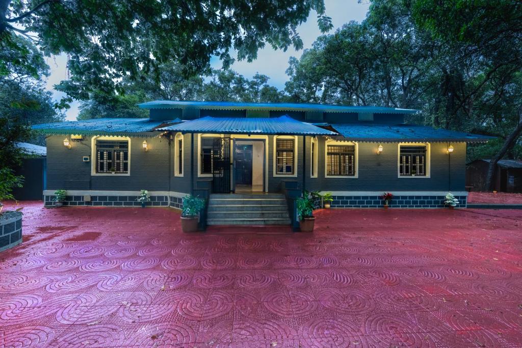 a house with a red carpet in front of it at Shalimar in the Forest in Matheran