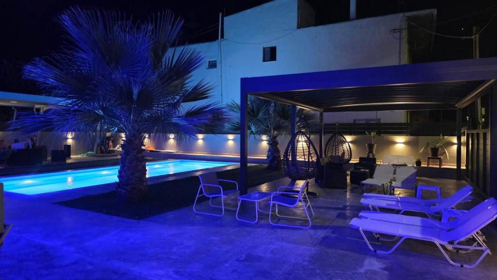a pool at night with chairs and palm trees at Luana Monte Apartments in Amoudara Herakliou
