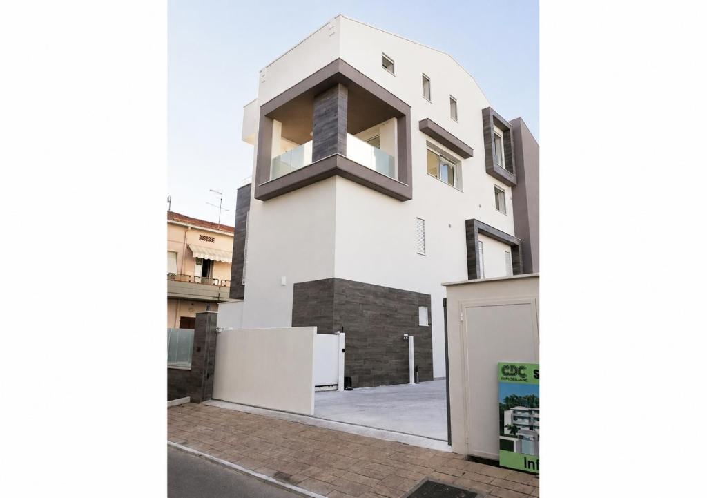 a white building with a window on the side of it at Holihome - Appartamento LA GIOIA in Tortoreto Lido