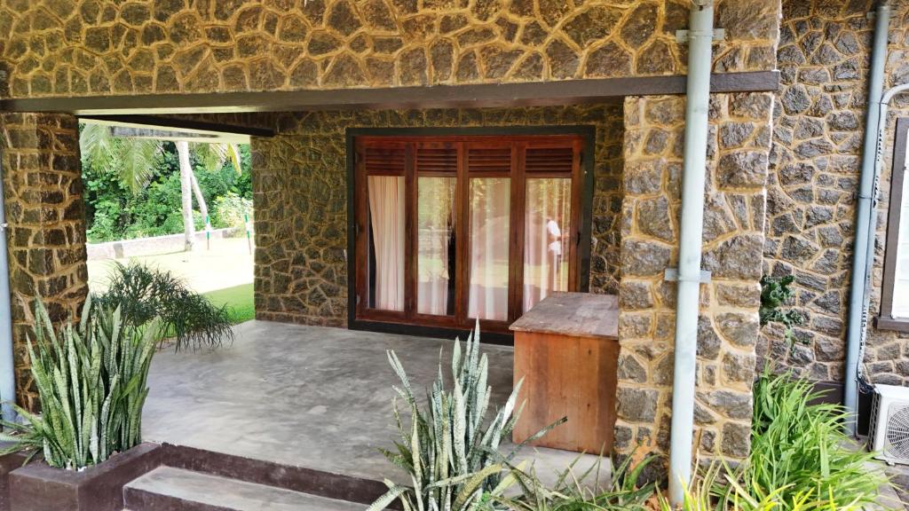 a stone house with a door and a stone wall at Gal Bungalow in Elpitiya