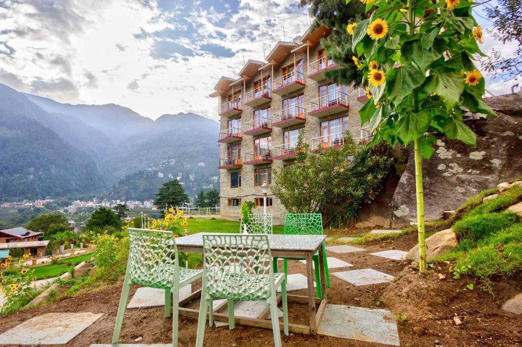 a table and chairs in front of a building at Snow City's Montana Blues Resort Manali - Heated & Air-Cooled Stay in Manāli