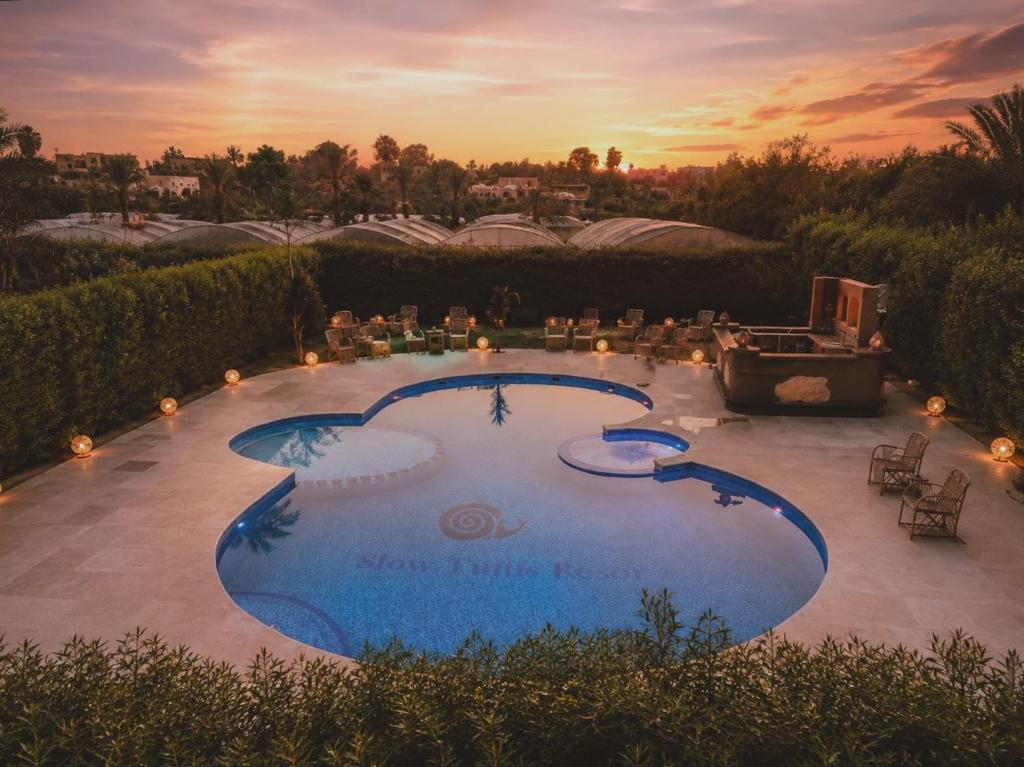 a large swimming pool with a sunset in the background at Slow Tunis in Tunis