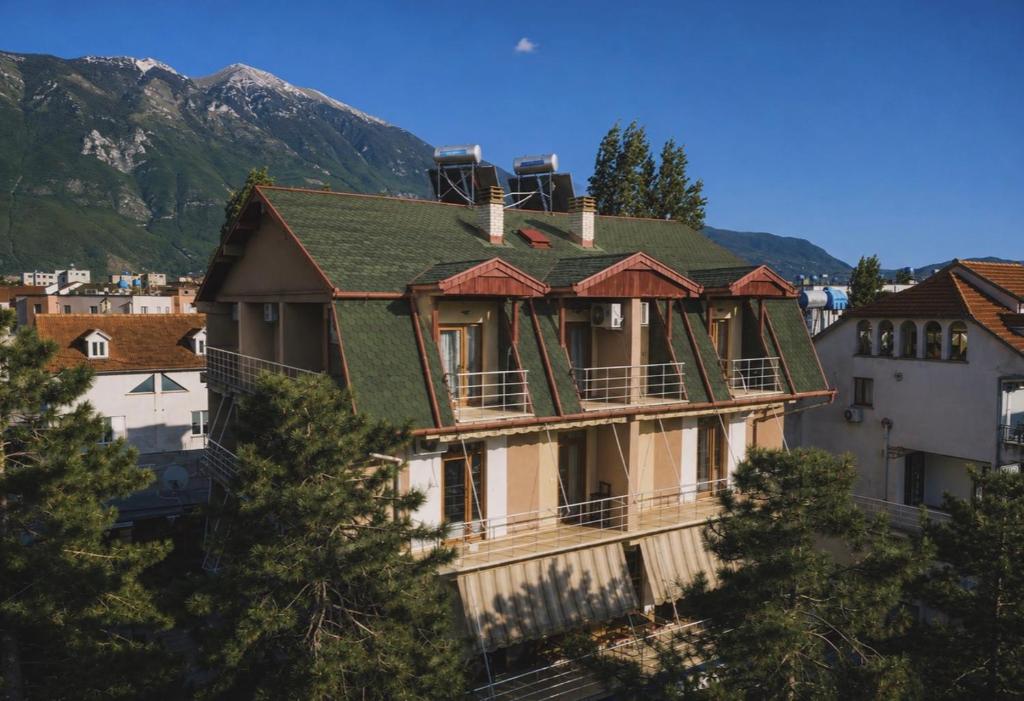 a building with a green roof on a mountain at Bar Hotel Tirana in Kukës