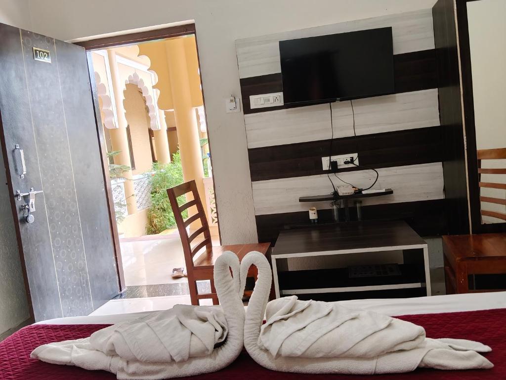 two swans towels sitting on top of a bed at L S Haveli - A Heritage Lake View Haveli in Pushkar