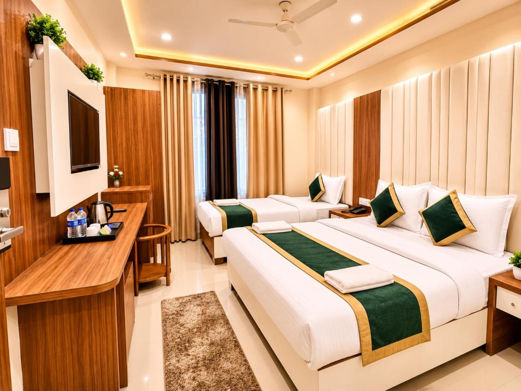 a hotel room with two beds and a television at HOTEL NEAR KASHI VISHWANATH VARANASI SHREE R-KRISHNA - wifi - Lift - FAMILY HOTEL in Varanasi