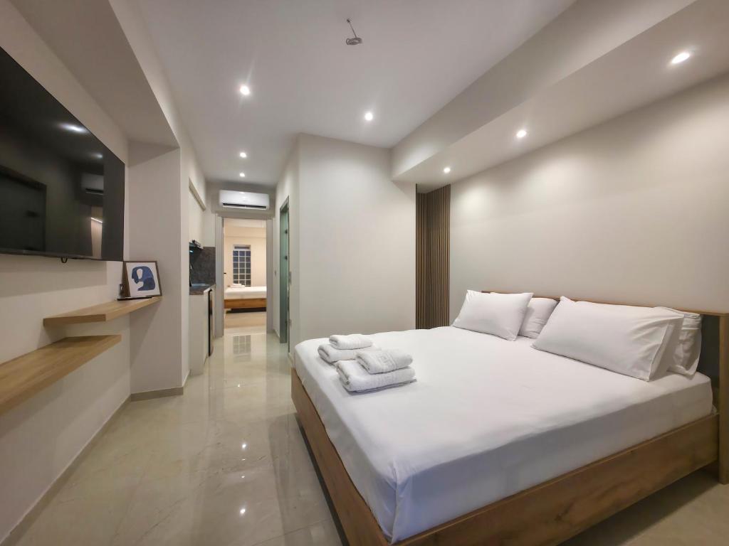 a bedroom with a large bed with towels on it at Lucia Hotel Paralia in Paralia Katerinis