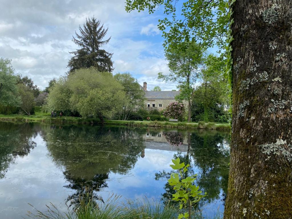 a view of a lake with a house in the background at Le Manoir de Gourvinec in Saint-Nolff