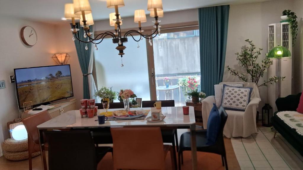 a living room with a dining table and a television at Daol in Seoul