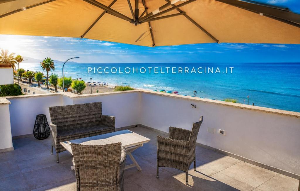 a patio with chairs and a table with a view of the ocean at Piccolo Hotel in Terracina