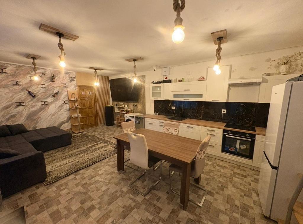 a kitchen and living room with a wooden table at Sixtor hause in Salonta