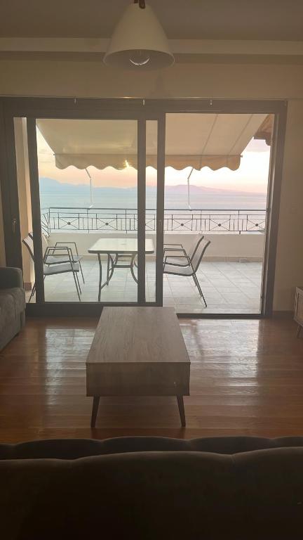a living room with a table and a view of the ocean at Panorama in Menídion