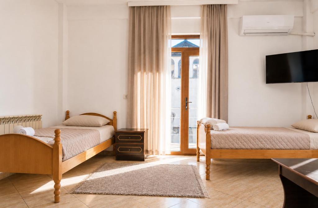a hotel room with two beds and a television at Bar Hotel Tirana in Kukës