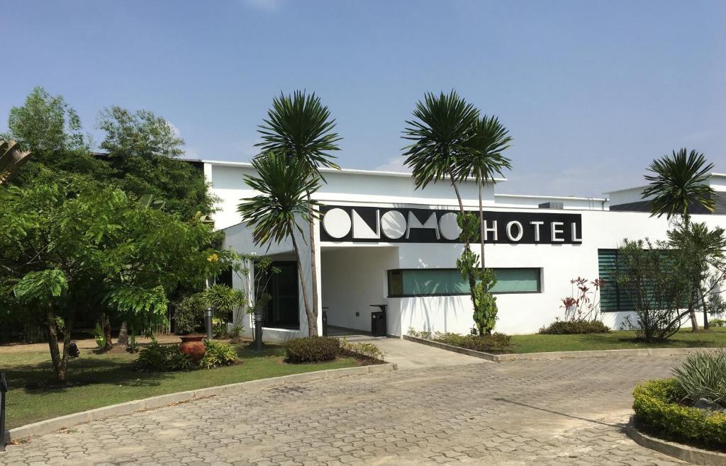 a hotel with palm trees in front of it at ONOMO Hotel Libreville in Libreville