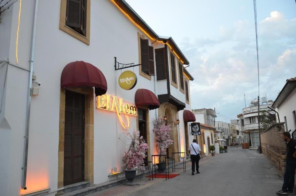 a man walking down a street next to a building at Nagas Premium Hotel in Yenişehir