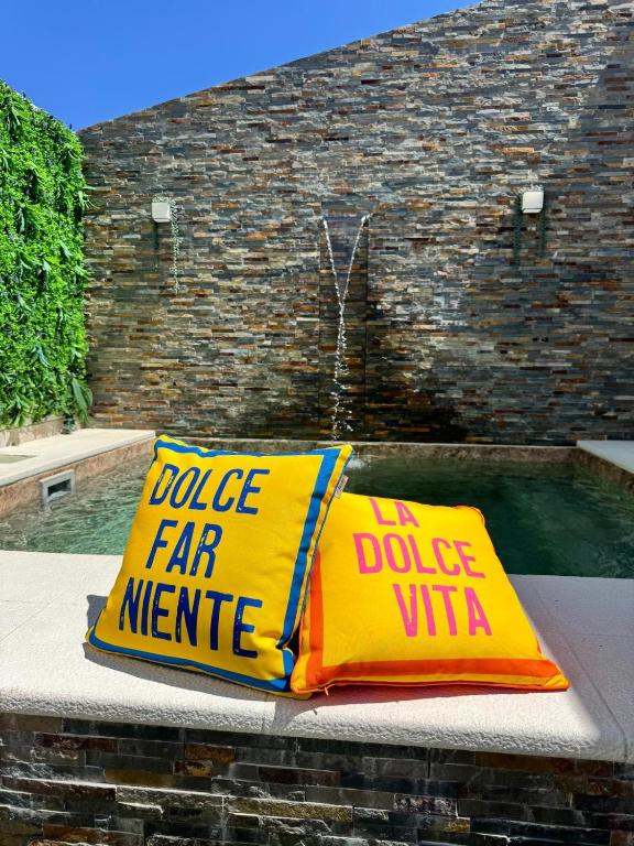 a yellow pillow sitting on a bench next to a pool at Casa da Laje - Casas BemHaja in São Miguel de Acha