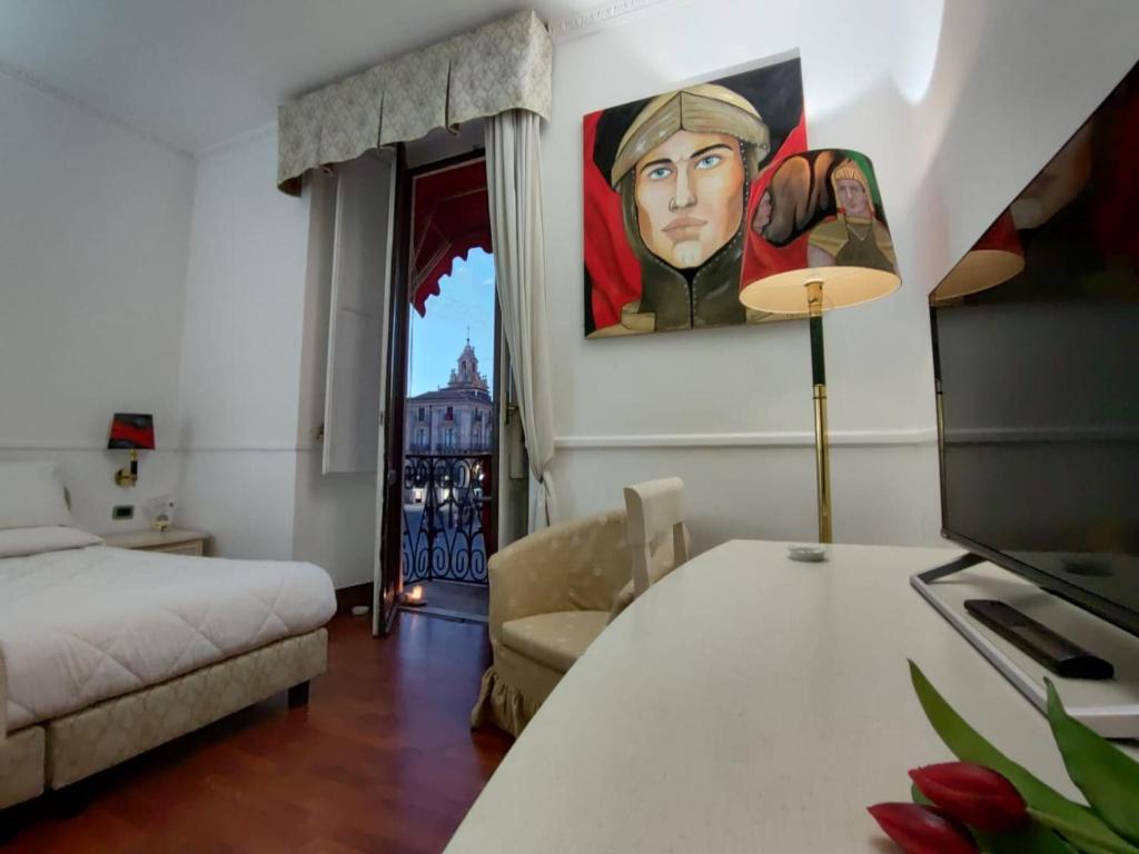 a bedroom with a bed and a painting on the wall at B&B Palazzo Sant'Alfano in Catania