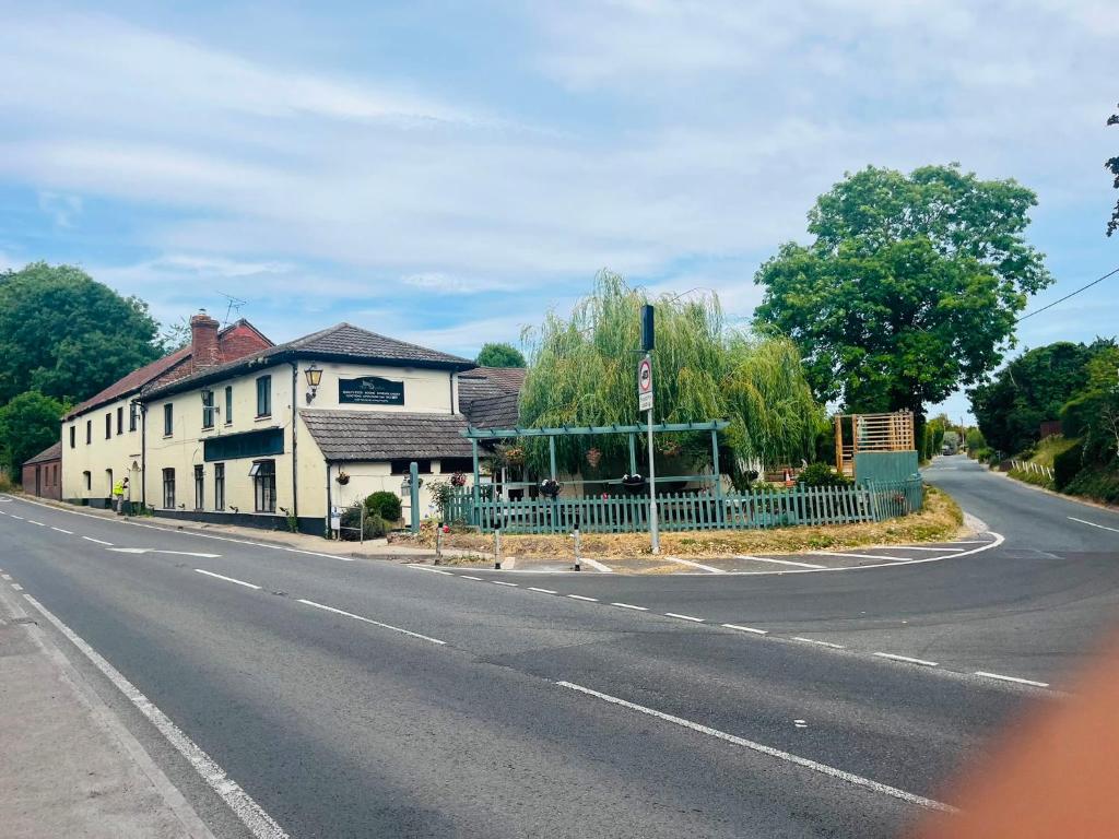an empty street with a house and a fence at Stopover Stoford in Stoford