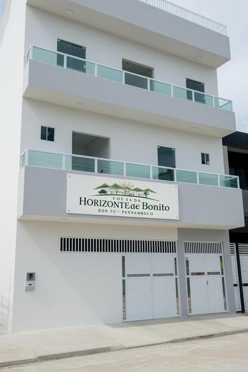 a white building with a sign that reads i homewrite boutique at Pousada Horizontes de Bonito Apto in Bonito