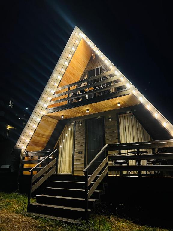 a house with stairs and lights on it at night at Gerlik Cottage in Mestia