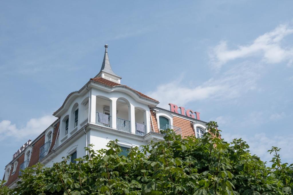 a building with a clock tower on top of it at Seminar-Hotel Rigi am See in Weggis