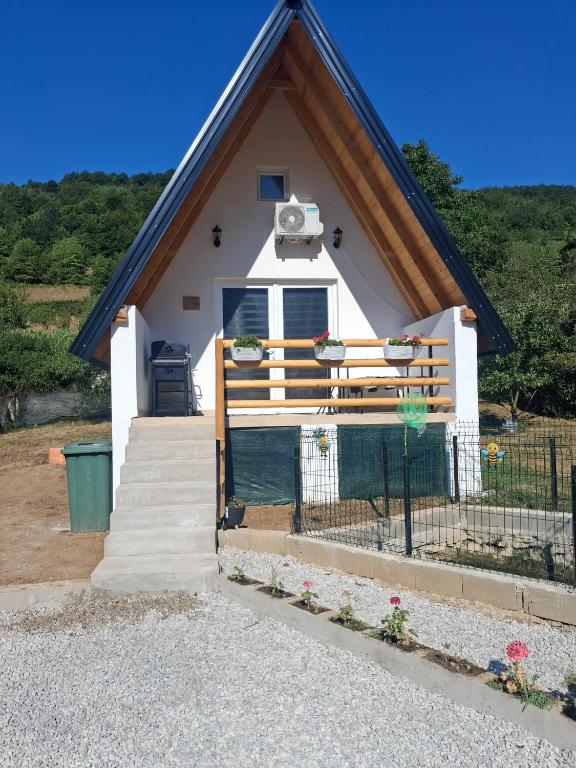 a small white house with a fence and stairs at Lajlas home in Orašac