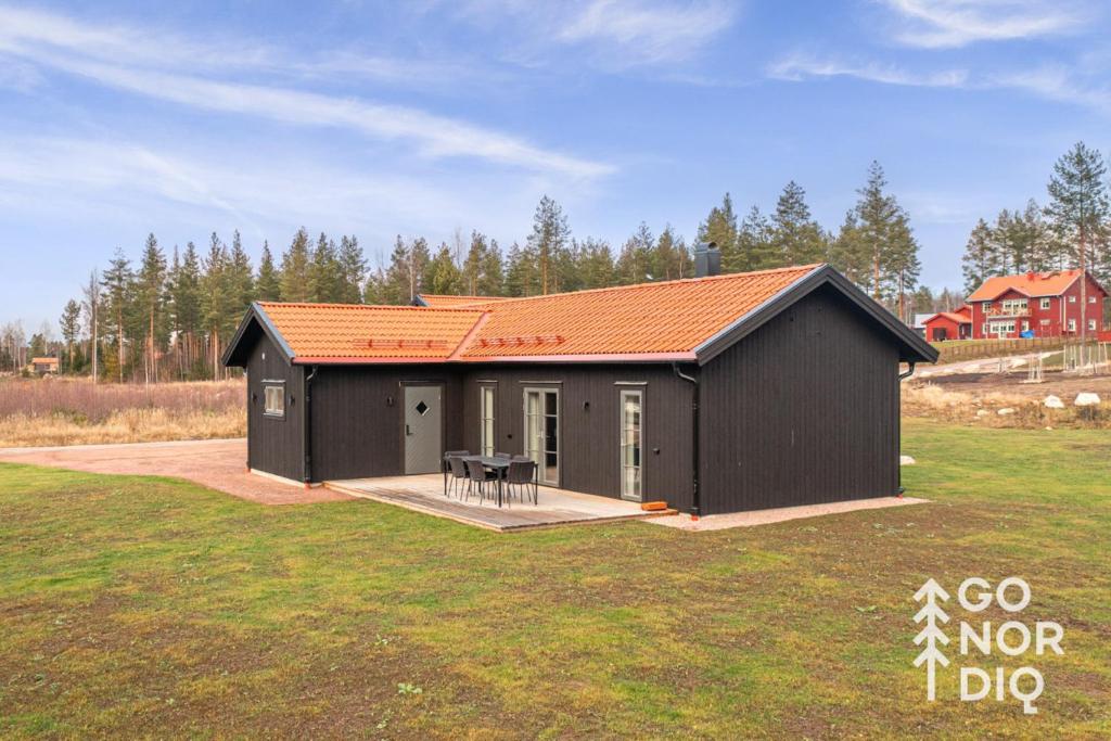 a small black shed with a table in a yard at Black Grouse Lodge in Tällberg