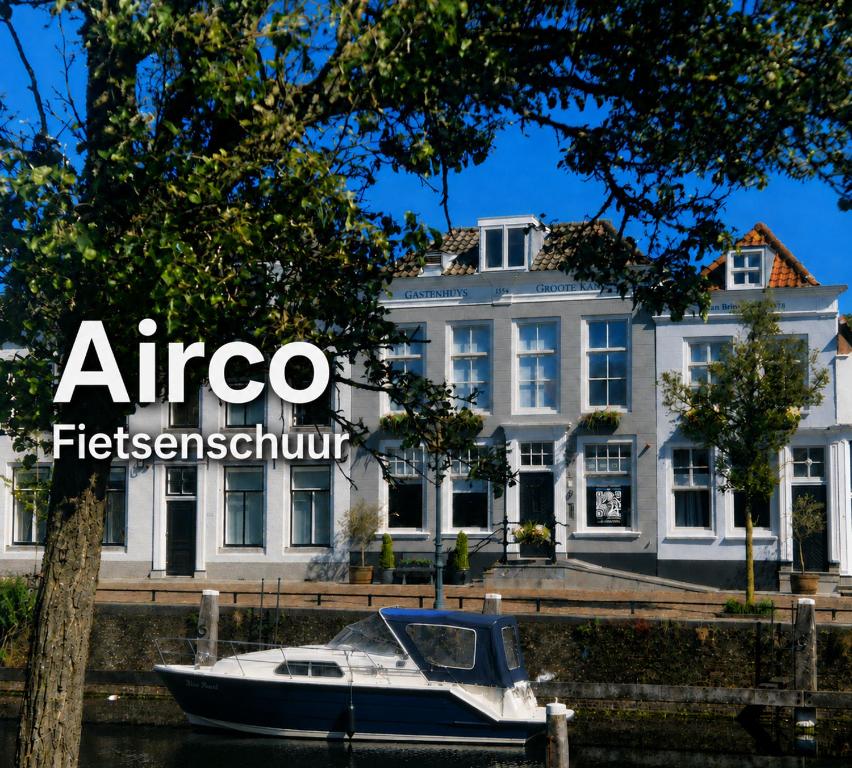 a boat in the water in front of a building at Boutique Hotel De Grote Kade in Goes