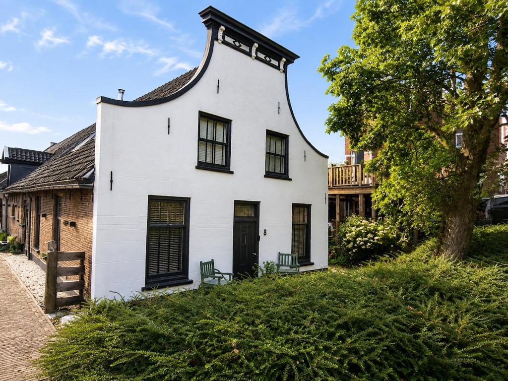 a white house with a black roof at Cozy apartment in authentic farmhouse in Gouda