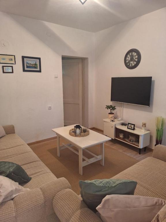 a living room with a couch and a table and a tv at Apartman Tanja Trebinje in Hrupjela