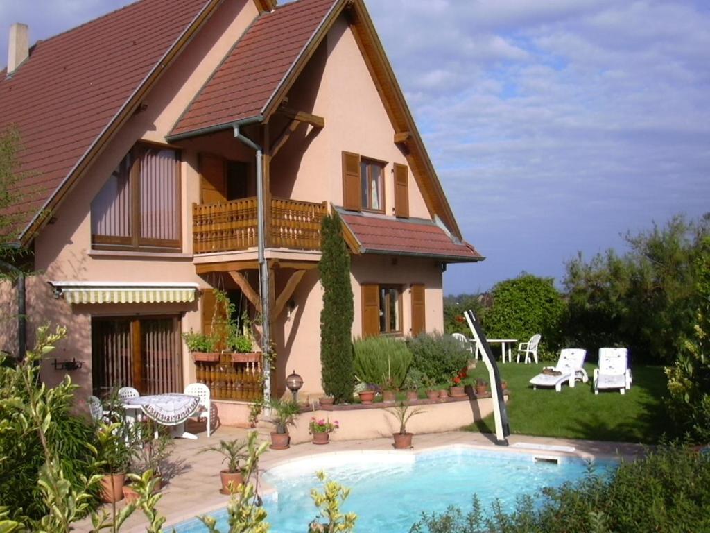 a house with a swimming pool in front of it at Vignoble in Bennwihr