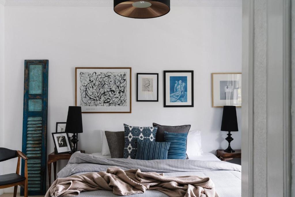 a bedroom with a bed and framed pictures on the wall at Piccadilly House Daylesford in Daylesford
