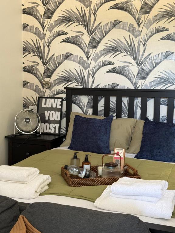 a bedroom with a bed with a tropical wallpaper at Rutland Point in Uppingham