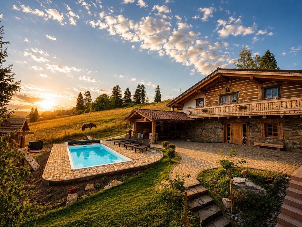 a log house with a swimming pool in front of it at Chalet Laitner in Yasinya