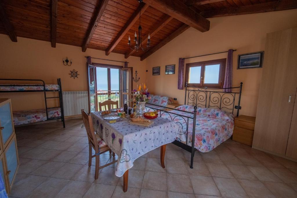 a bedroom with a table and a bed and a dining room at Strada Casai 19 - Appartamento turistico in villa con giardino e posto auto in Riva Ligure
