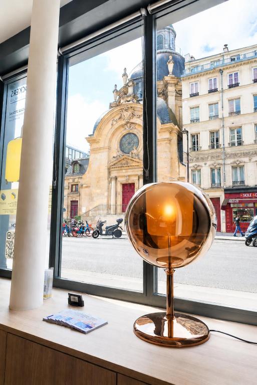 a glass orb sitting on a window sill at Hôtel De La Herse d'Or in Paris