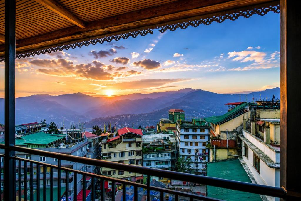 a view from a balcony of a city at sunset at Sparrow Elements Boutique 2 min walk To Mg Marg in Gangtok